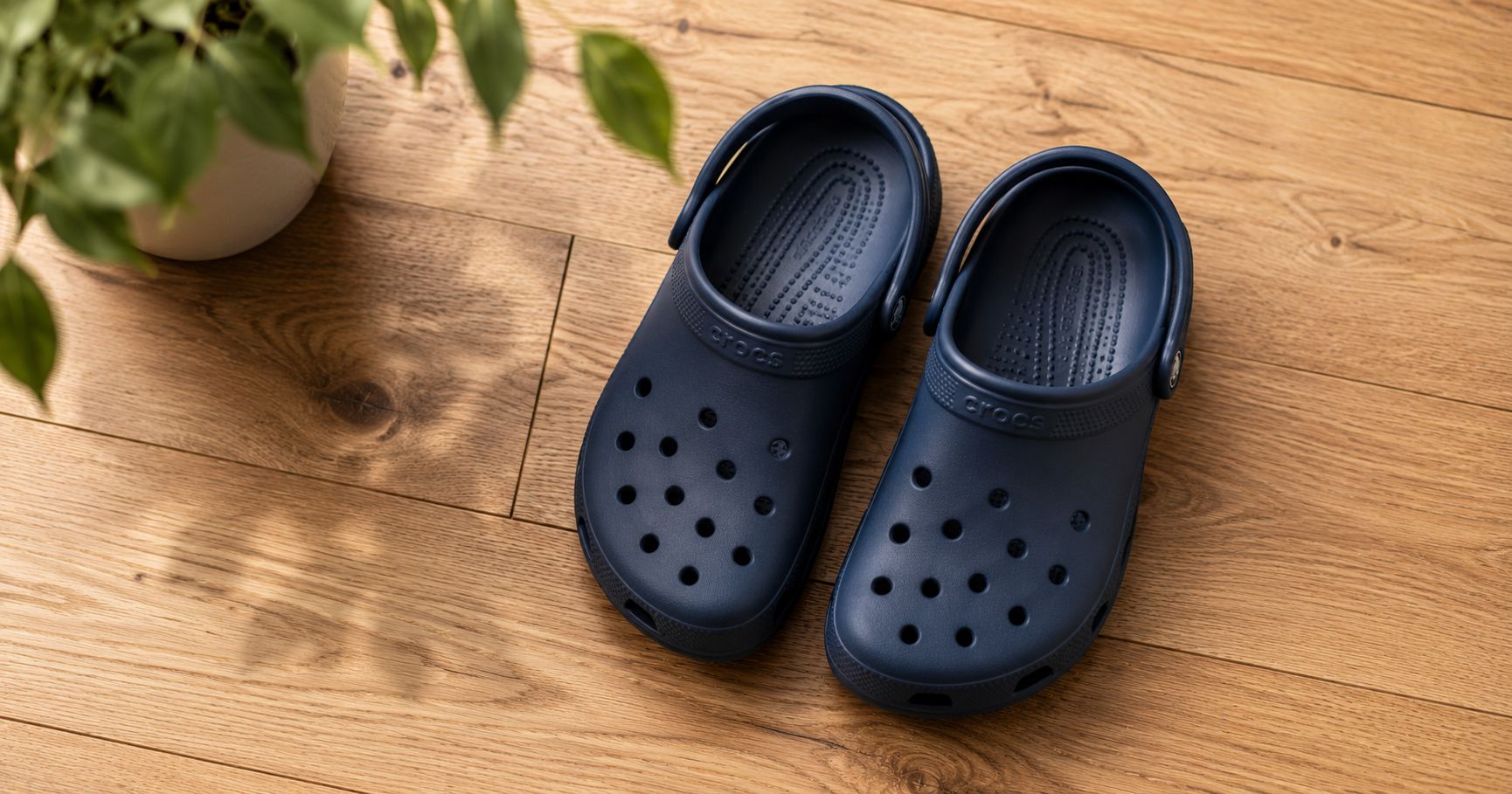 are Crocs bad for your feet, a pair of classic Crocs clogs on a wooden floor