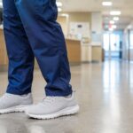 shoes for standing all day, a worker in supportive sneakers on a hard floor during a long shift